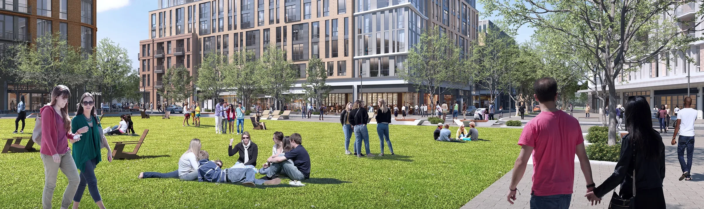 The Village Green at the Pattern District in Newton Upper Falls, MA, featuring open green space, walkable pathways, and surrounding mixed-use buildings.