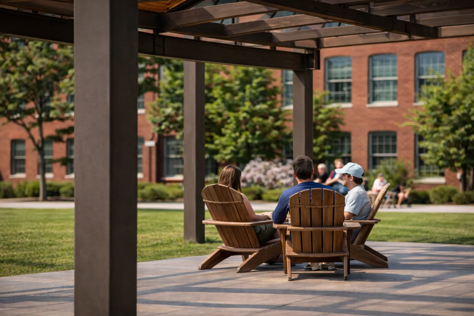 Residents gathering in an outdoor courtyard at the Pattern District in Newton Upper Falls, MA, featuring landscaped green space and communal seating.