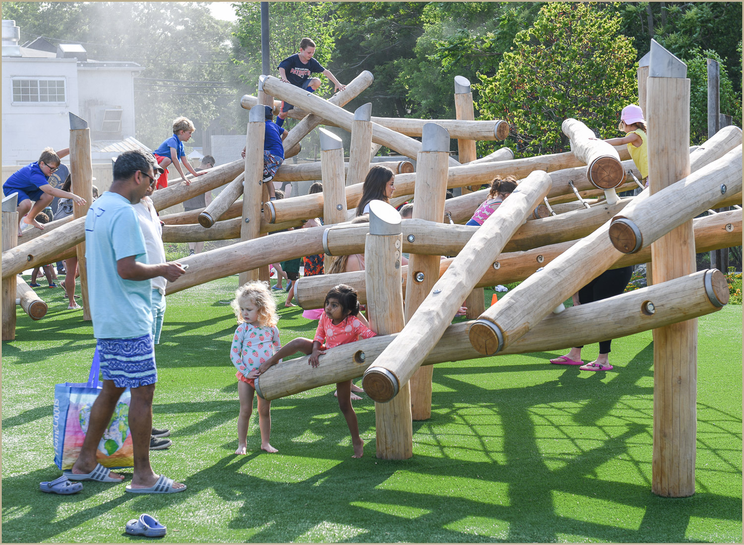 Children playing on a nature-inspired playground at the Pattern District in Newton Upper Falls, MA.