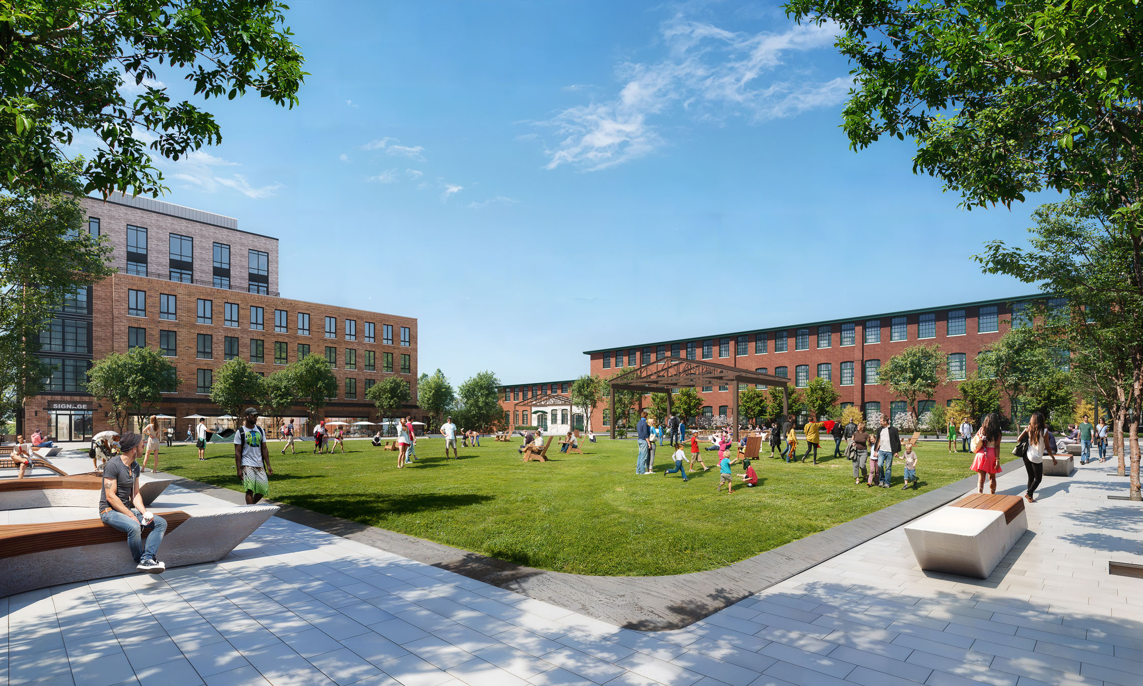 The Village Green at the Pattern District in Newton Upper Falls, MA, featuring open lawn space, community gathering areas, and restored mill buildings.