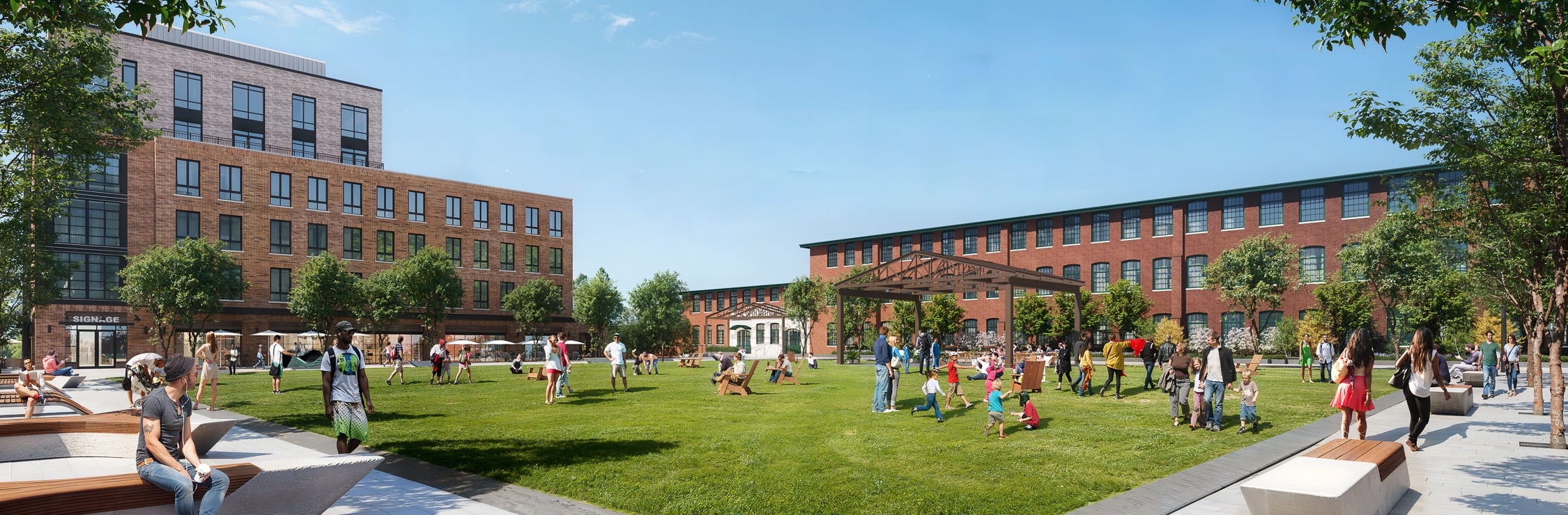 The Village Green at the Pattern District in Newton Upper Falls, MA, featuring open lawn space, community gathering areas, and restored mill buildings.