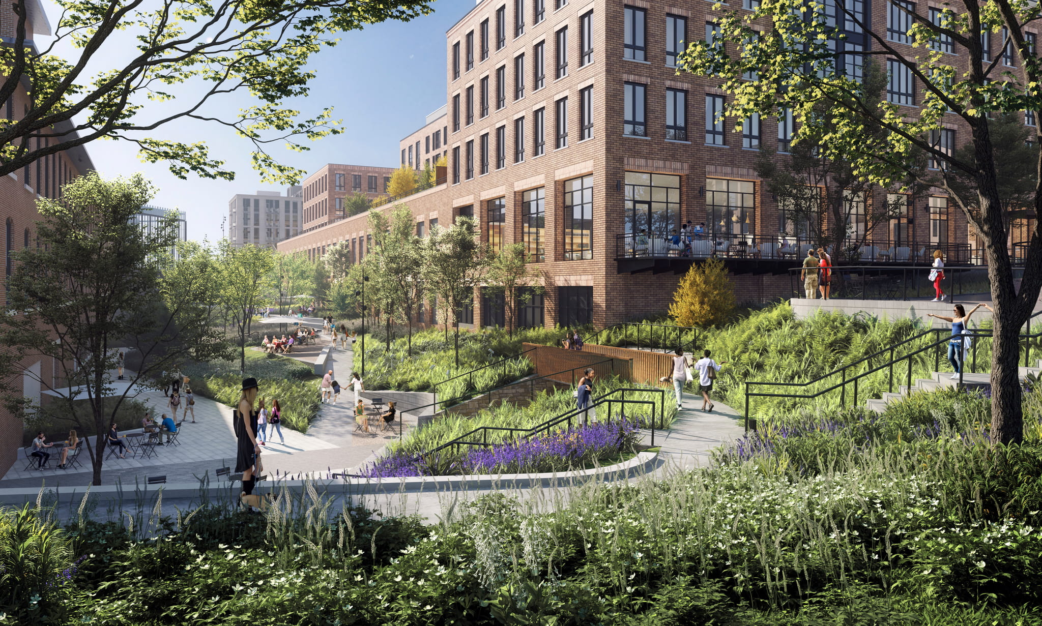 Landscaped pedestrian walkway and outdoor gathering spaces at the Pattern District in Newton Upper Falls, MA, featuring modern mixed-use buildings and terraced green space.